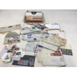 A quantity of world stamps and envelopes in a cigar box