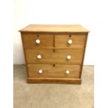 A Victorian pine chest of drawers stamped Heal and sons London. With ceramic handles on two short