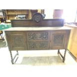 A carved sideboard with two central drawers flanked by cupboards also with carved back, barley twist