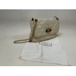A Lulu Guinness cream leather quilted hand bag with gold coloured chain strap - with storage bag