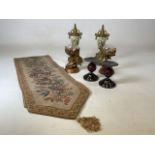 A quantity of decorative items including candlesticks, gilded metal urns and a table runner