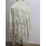 A vintage cream silk fringed wedding shawl with floral embroidery