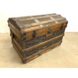 A wooden and metal bound domed top steamer trunk. W:84cm x D:51cm x H:58cm