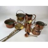 A quantity of copper and brass items including a watering can, a pitcher, jugs, cauldron styles pots