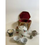 A Japanese style tea pot and cups in wicker basket also with other oriental style items