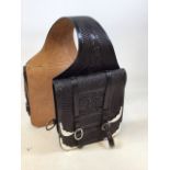 A pair of tooled and trimmed leather saddle bags