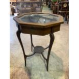 An octagonal inlaid bijouterie table with material lined interior and octagonal under shelf. W: