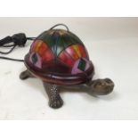 In the manner of Tiffany, a tortoise table lamp with coloured glass shell. Untested, wired with 3-