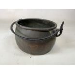 An antique copper cauldron cooking pot with cast iron swing handle with riverbed handle holder -