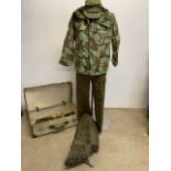An early 1960s suitcase with assorted military items. A combat jacket, 1950s trousers, a kit bag,