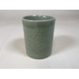 A twentieth century Chinese celadon brush pot with embossed dragon design W:10cm x H:13cm