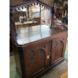 An early 20th century oak sideboard with carved details and large mirror, with internal drawers