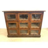 A Late Victorian pine haberdashery or shop keepers cabinet with nine glazed drawers with brass