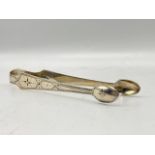 Georgian silver sugar tongs with engraved detailing and monogram. Makers mark for George