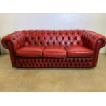 An Oxblood red leather Chesterfield three seater sofa. W:190cm x D:88cm x H:72cm