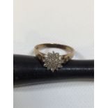 A diamond cluster ring with diamond studded shoulders in 9ct gold. Total weight approx 2gm. Size M