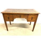 An early 20th century solid oak desk, (top a.f) with central drawer flanked by two deep drawers.