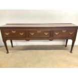 A large oak Georgian dresser base with three drawers with brass handles and decoration with