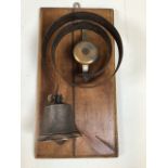 A servants bell mounted on wooden plinth. W:32cm x H:17cm