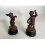 A pair of vintage bronzed spelter winged cherubs mending broken hearts both in distinctly signed .