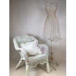 A wire mannequin also with a painted wicker chair with cushion