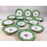 A hand painted nineteenth century green and floral gilded and enamelled set of eighteen 24cm