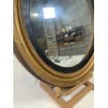 A large regency style mid 19th century gilt framed convex mirror with black painted inset border.