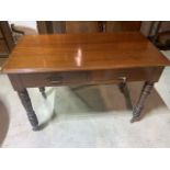 An early 20th century mahogany two drawer desk with brass handles ands turned legs to brass and
