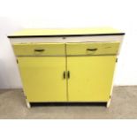 A mid century lemon yellow Swedish kitchen cupboard with two drawers above cupboards. With formica