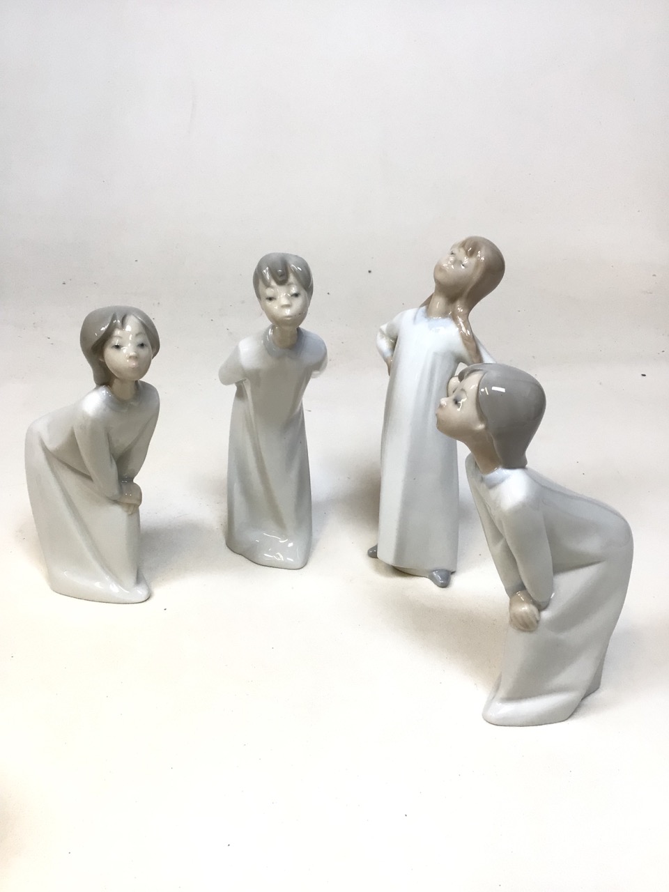 Four Lladro figurines includes girl stretching and girl kissing with other ceramic items