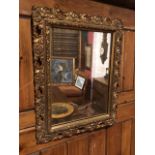 Small gilt metal framed hall mirror, with relief foliate detail. Lightly foxed mirror plate (24cm