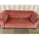 A button back upholstered chesterfield sofa. Victorian settee with drop arm.