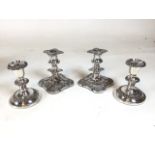 2 pairs of silver plate candlesticks, one with leaf and berry detail, the other pair have reeded