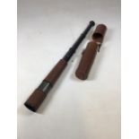 A military three draw telescope with a textured brown body in a leather case. H:80cm Fully extended
