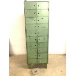 A bank of mid century metal pigeon hole lockers with original vintage green paint, with locks. Of