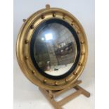 A Late 19th early 20th century convex mirror with gilt circular frame and ebonised interior