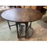 An oak gate leg table with bobbin turned legs. W:114cm x D:89cm x H:73cm