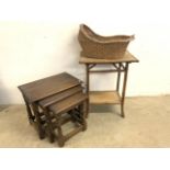 A bamboo table, wicker crib and an oak nest of tables.