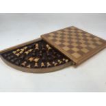 A complete wooden chess set with pull out drawer with storage for pieces.