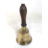 Polished brass school bell with wooden handle. Slight crack to bell housing, but good condition