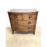 A Victorian flame mahogany bow front chest of drawers with two short over toe long drawers. Turned