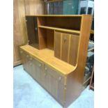 A mid century G Plan style sideboard, with glazed cupboard, drop down bar and base with three