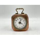 A small travel clock with 1½ inch dial with brass carrying handle. Untested. W:4.5cm x D:5.5cm x H: