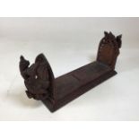 A vintage carved eastern style book slide decorated with Oriental Deities W:50cm x H:22cm width when