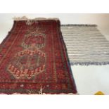 An antique Persian red rug and another. W:130cm x D:84cm