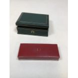 Two Omega watch boxes - a green box W:14cm x D:10cm x H:5cm and a red box W:14cm x D:6cm x H:2.5cm