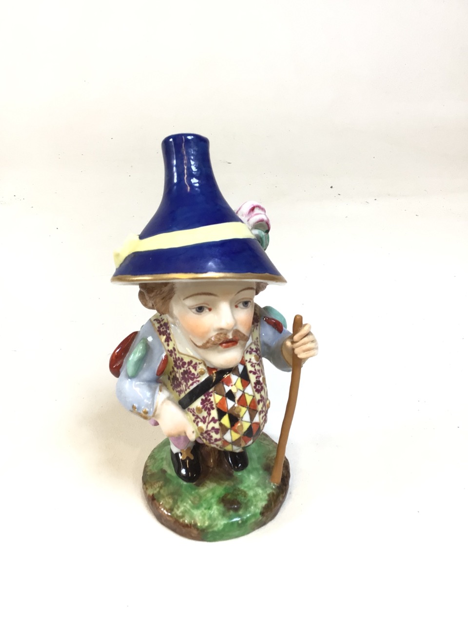 A Royal Crown Derby Pot Belly Dwarf with blue hat and harlequin and flower pattern vest. Circa