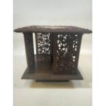 A Small carved revolving table top bookcase. Heavily carved with leaves and berries on square