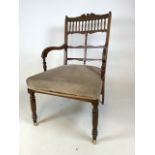 An Edwardian decorative inlaid ladies arm chair with small ceramic and brass castors with turned and