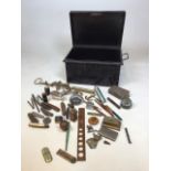A metal deed box with a quantity of collectibles including pens, paperweights, knives, lighters
